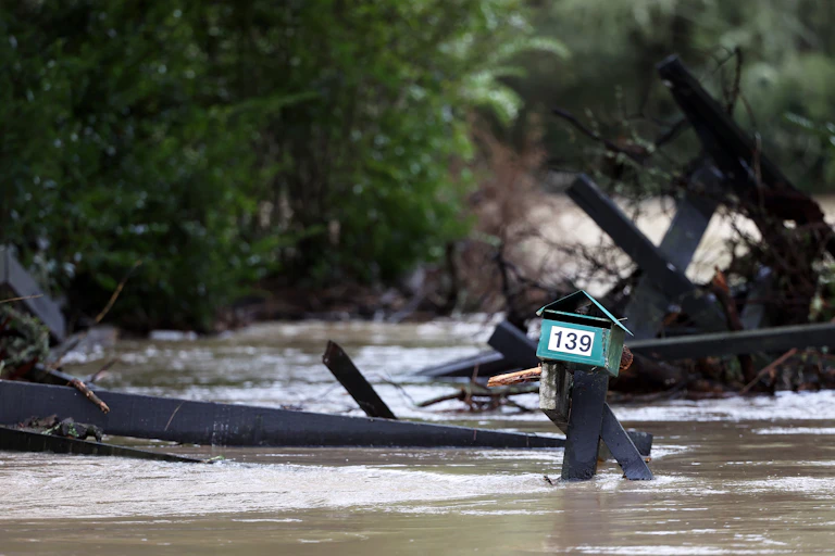 Bridge and fencing destroyed by flooding after heavy rain. Only post box is visible.