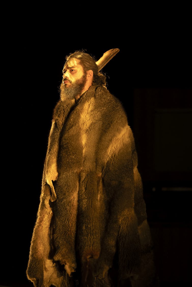 Production image: a man in a possum skin cloak.
