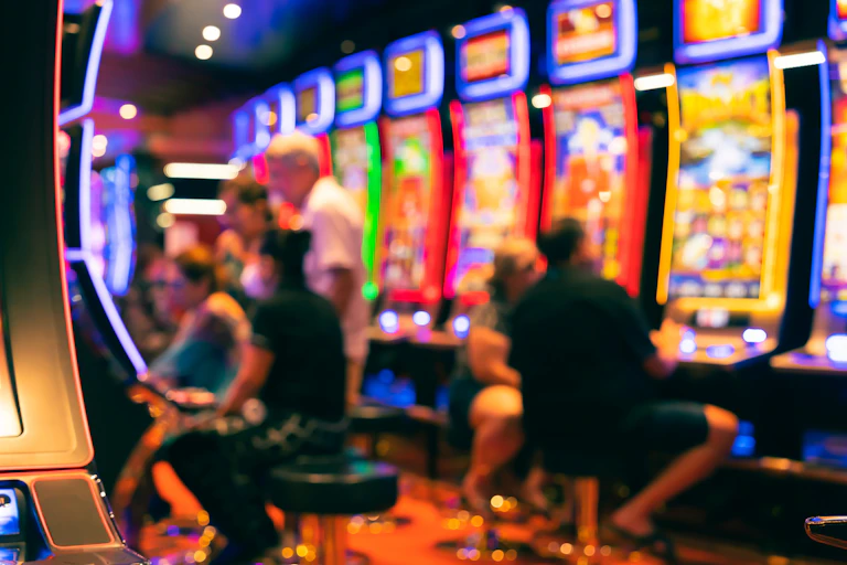 A blurred images of gamblers using pokie machines.