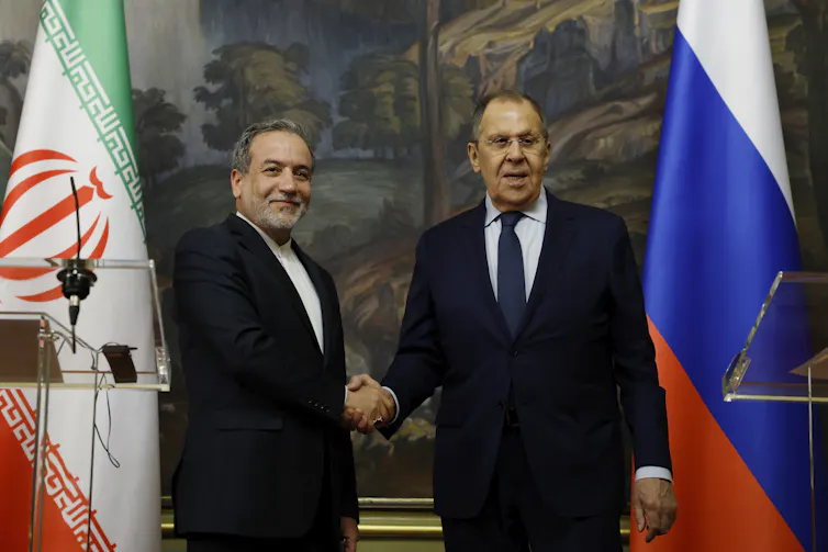 Russia's foreign minister, Sergei Lavrov, shakes hands with his Iranian counterpart, Abbas Araghchi.
