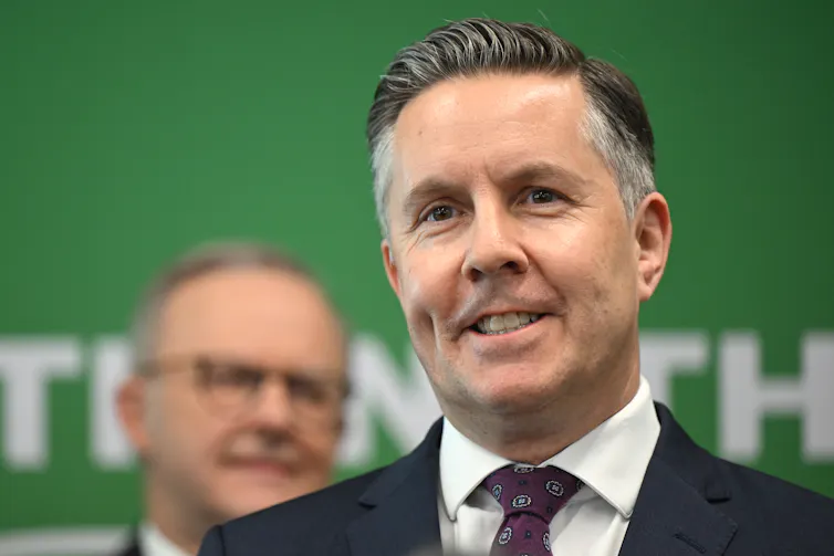 Mark Butler smiles in front of Anthony Albanese