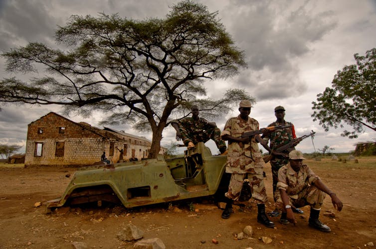 ‘Killing is part of their life’: the lads raised on violence who're each perpetrators and sufferers as South Sudan faces go back to civil struggle 1 Armed soldiers pose in front of a destroyed army jeep with a ruined building behind them.
