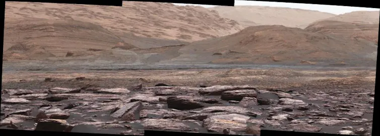 ensemble de photos composant un panoramique sur Mars, on voit des rochers et des pentes rougeâtres