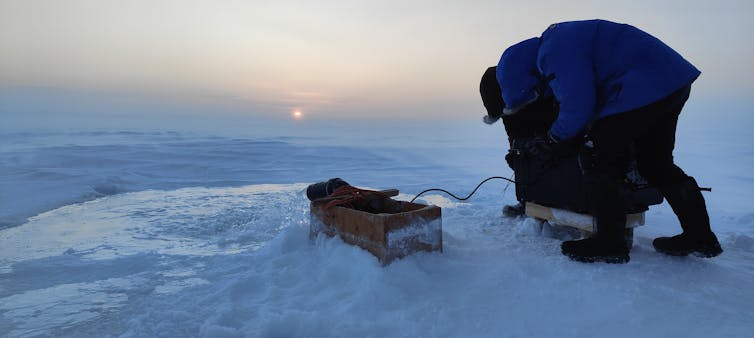 Man with water pump on ice