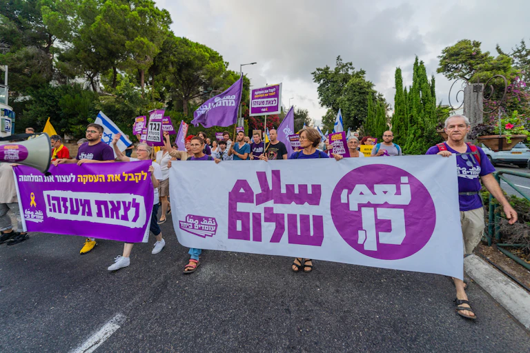 Marche de protestation à Haïfa en Israël du 14 septembre 2024 avec divers panneaux et drapeaux, appelant à de nouvelles élections et à un accord sur les otages.