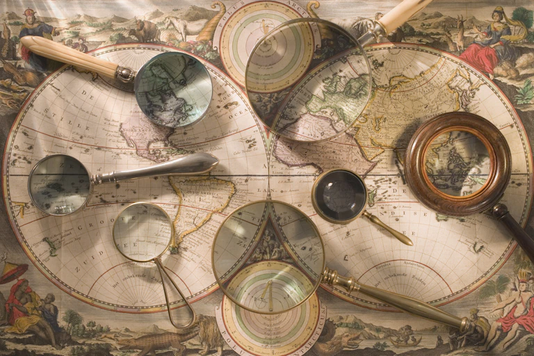 An antique map has various magnifying glasses on it.