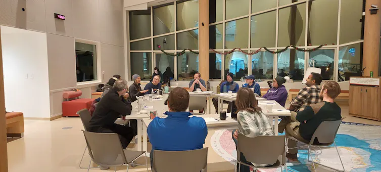 A group of people sit around a large table