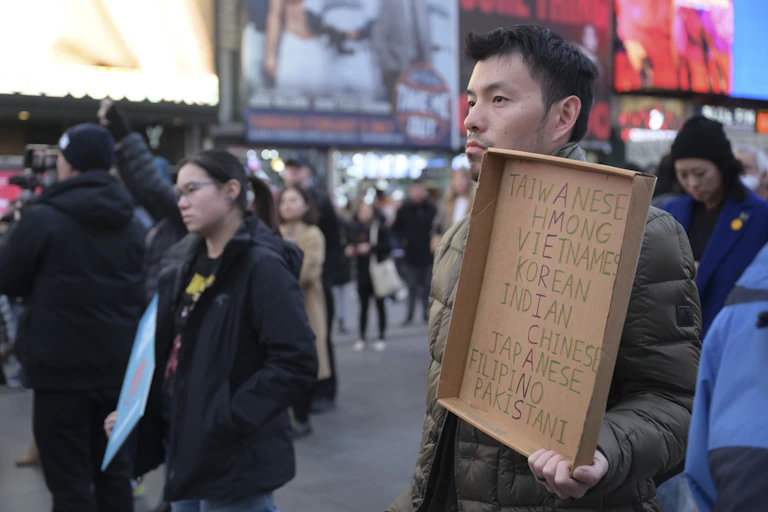 A man holds a sign at a rally.