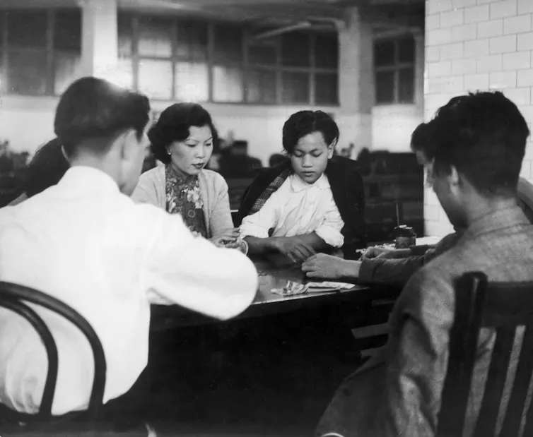 People gather at a table in an office.