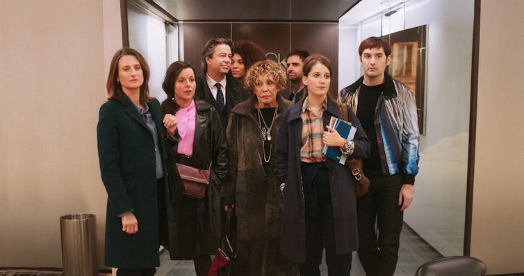 a group of 8 people gathered in a hallway