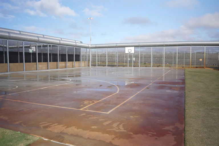A wet basketball court in a youth detention centre