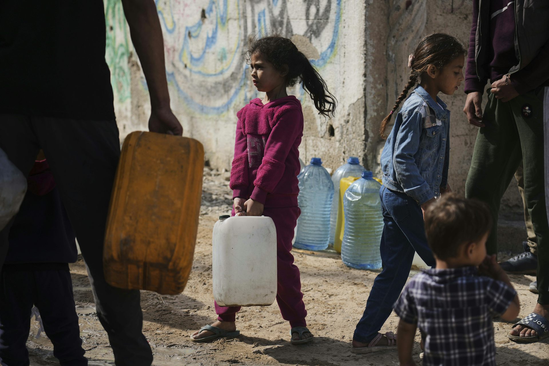 Une enfant porte un contenant en plastique