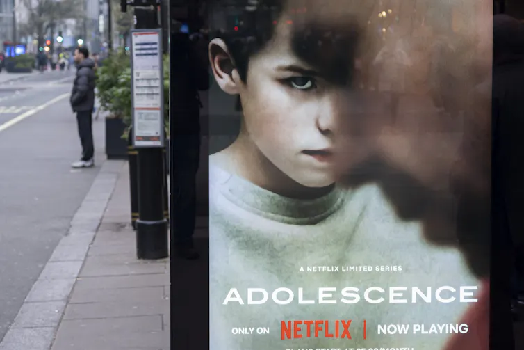 An advertising billboard shows a young boy's face over the word 'Adolescence'