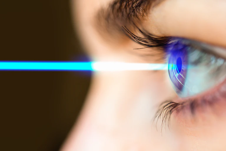 Un rayo de luz azul impactando en un ojo humano