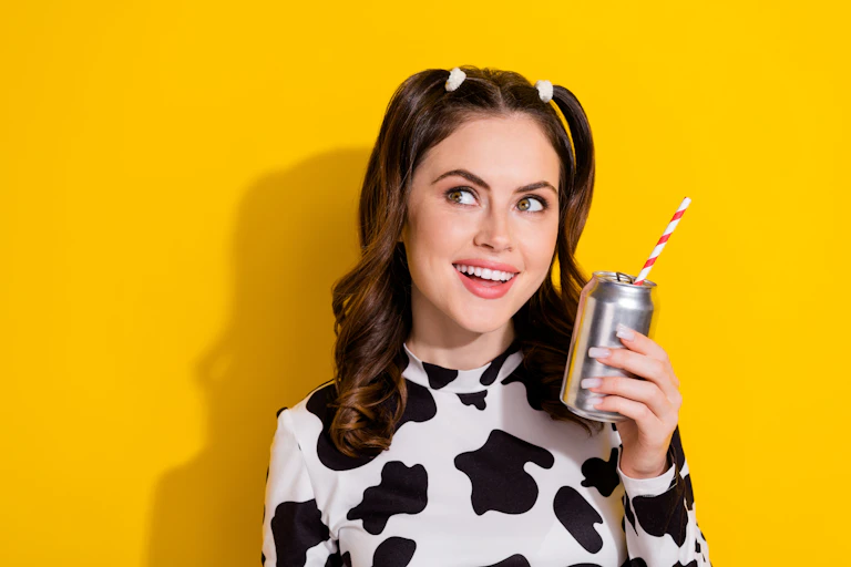 Mulher jovem segurando uma lata de refrigerante