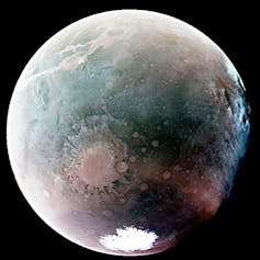 Mars shown from space, colored gray, green and brown.