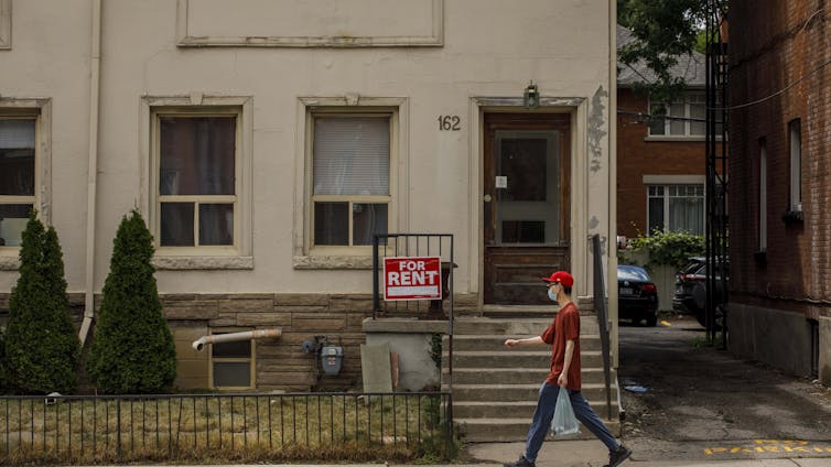 La persona camina firma para alquilar fuera del apartamento en la planta baja