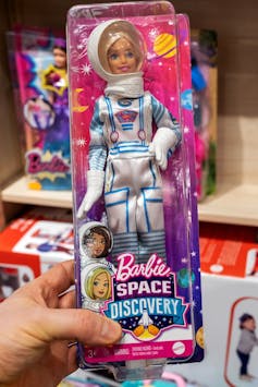 Person holding Astronaut Barbie in packaging