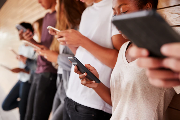 Teenagers looking at their phones.