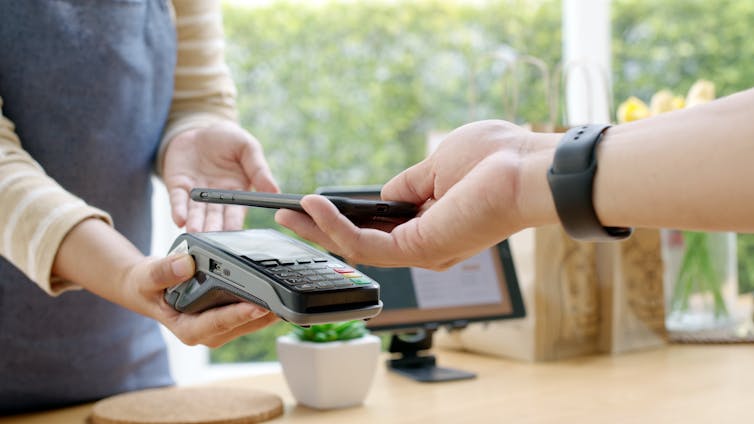Person paying by card in a cafe