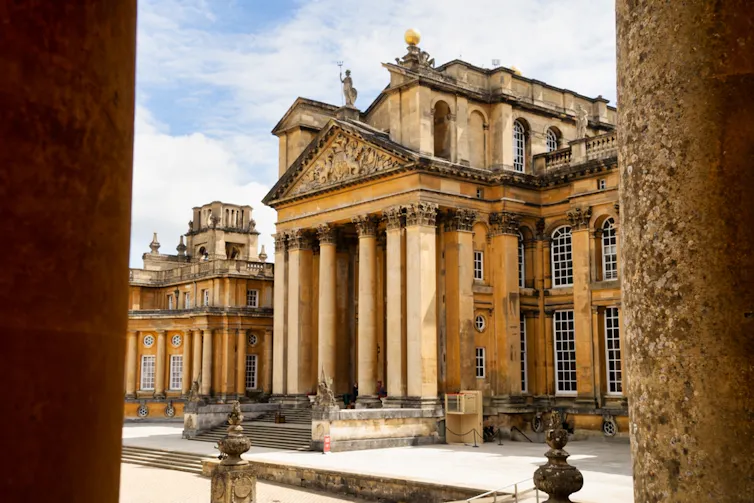 The front of Blenheim Palace seen between two columns.