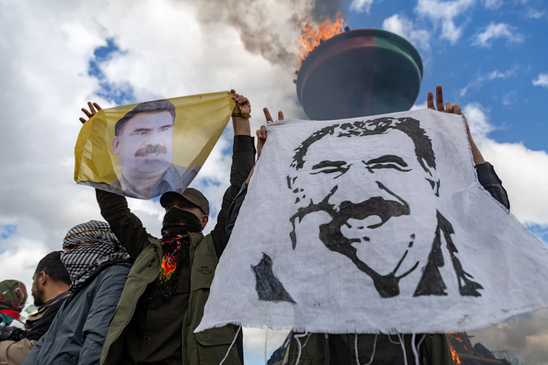 People hold pictures of the PKK's jailed leader, Abdullah Ocalan, during a rally.