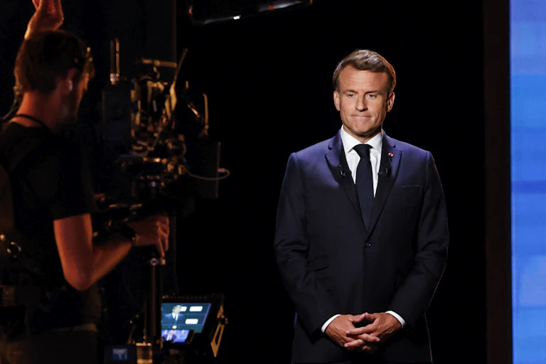 Le président macron, debout, fait face à une caméra sur le llateau de TF1 pour l'émission « Les défis de la France » sur TF1, le 13 mai 2025.