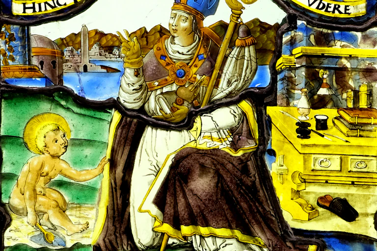 A man wearing a crown sitting on a chair with a child by his feet.