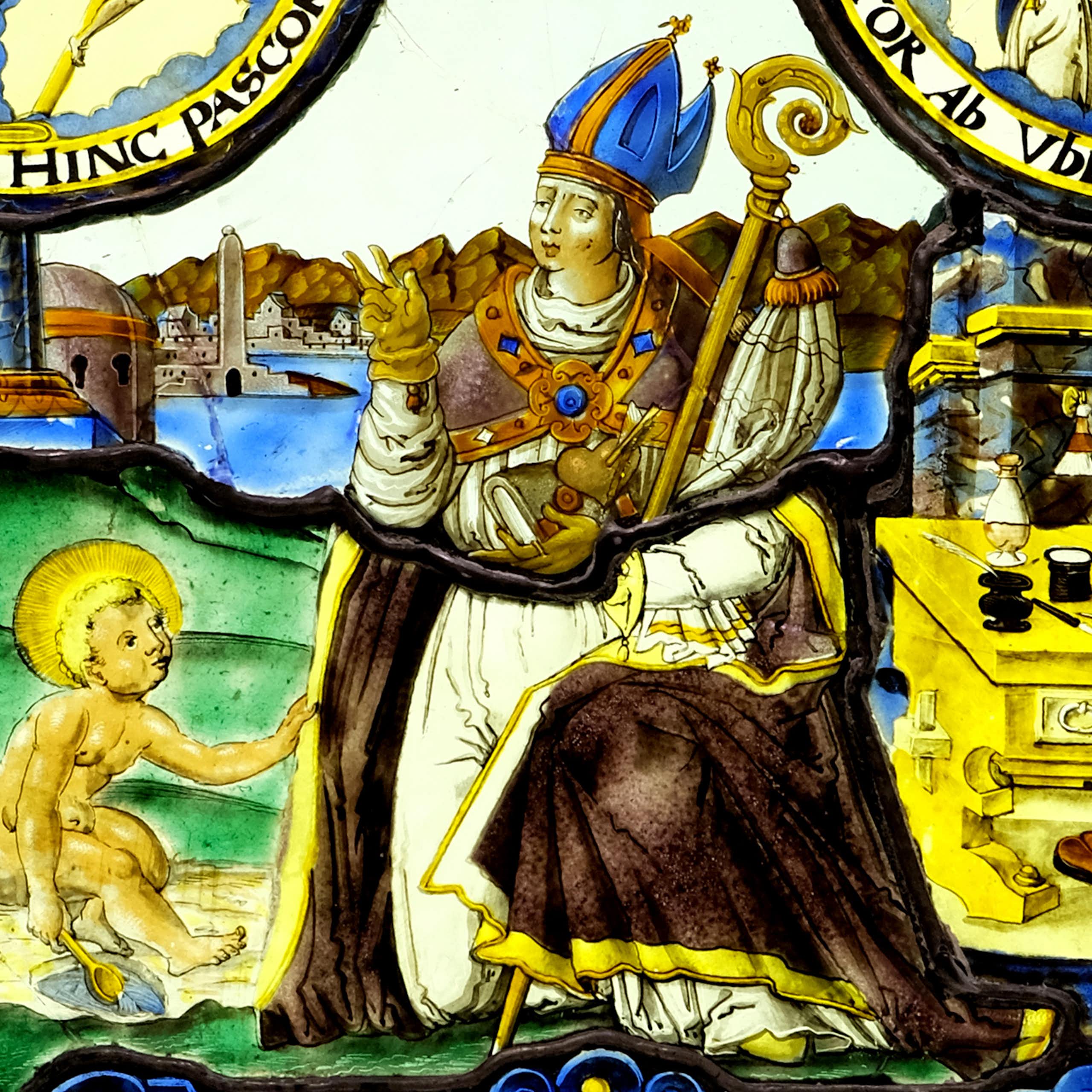 A man wearing a crown sitting on a chair with a child by his feet.