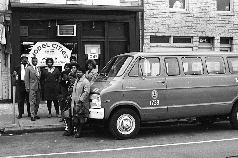 Group of Black people pose next to a van.