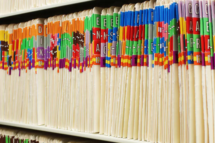 Rows of folders containing medical records on shelf