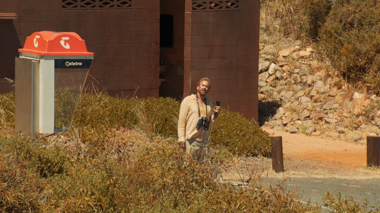 Cage stands next to a phone booth.