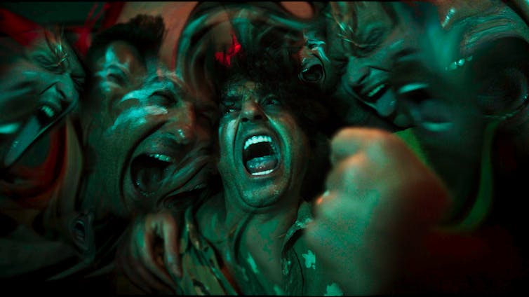 Men in a sweaty hug: perhaps they are cheering, or maybe they are yelling.