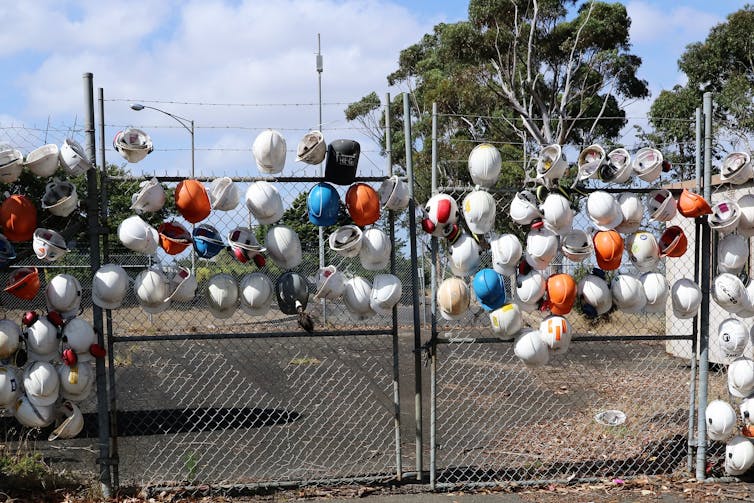 hardhats on fence.