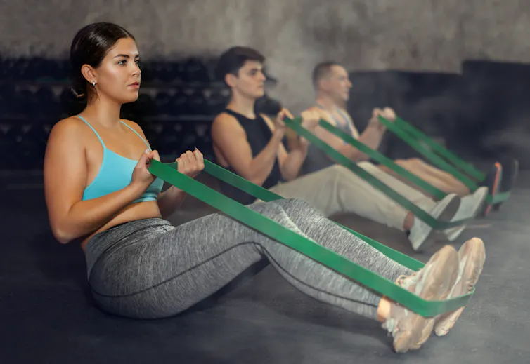 Tres personas practican crossfit en un gimnasio