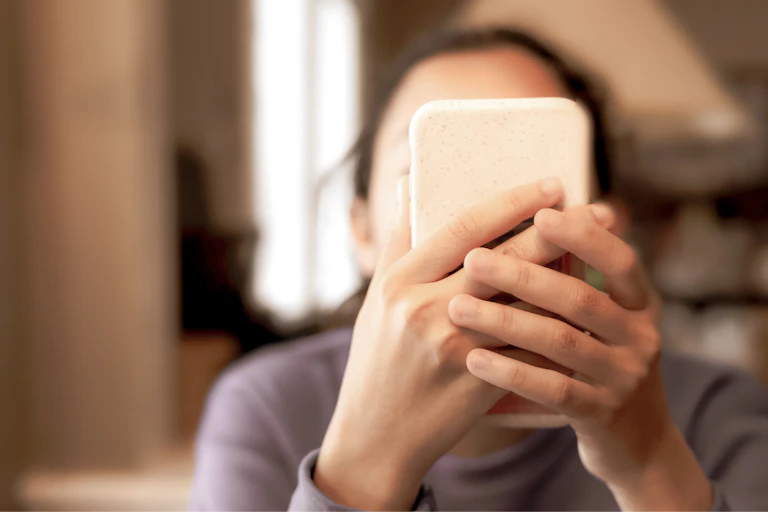 Woman holding a cell phone in front of her face