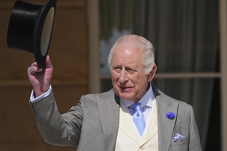 A man with a top hat waves.