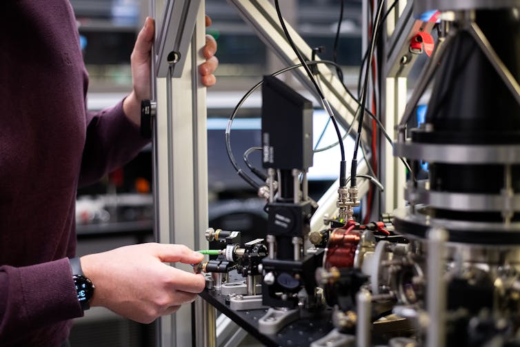 Photo of a person adjusting a complex device.