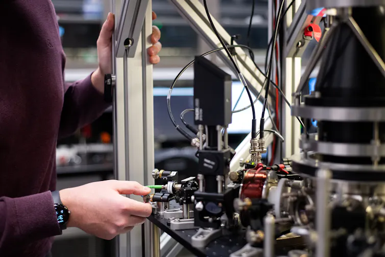 Photo of a person adjusting a complex device.