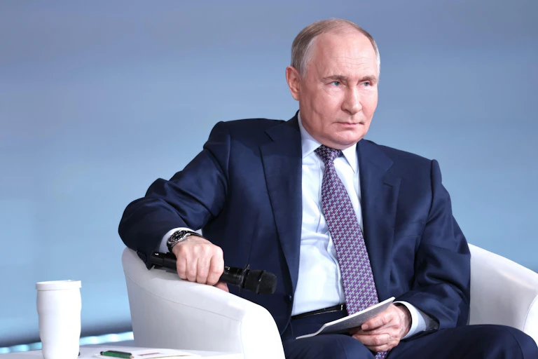 Vladimir Putin sitting.