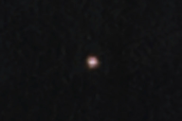 A small, blurry, bright dot against a dark sky.