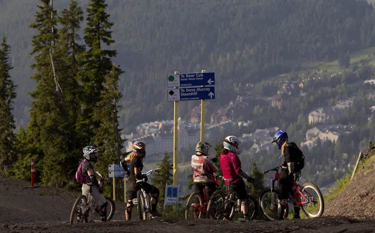 People on mountain bikes overlooking a valley.