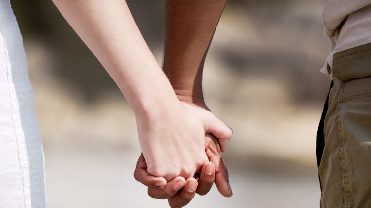 close up image of two people holding hands