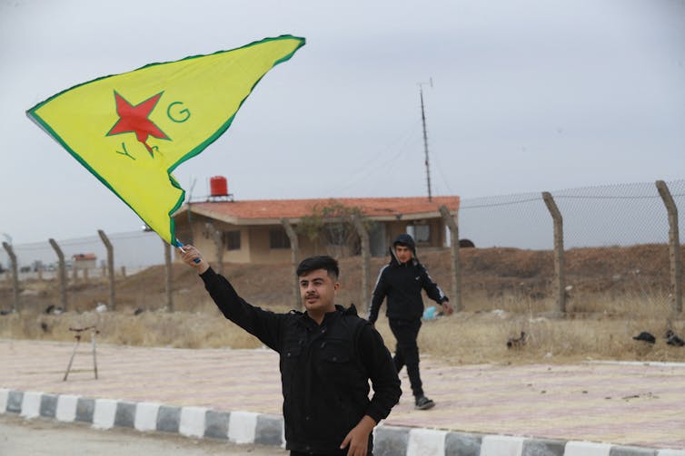 A man waves a yellow flag.