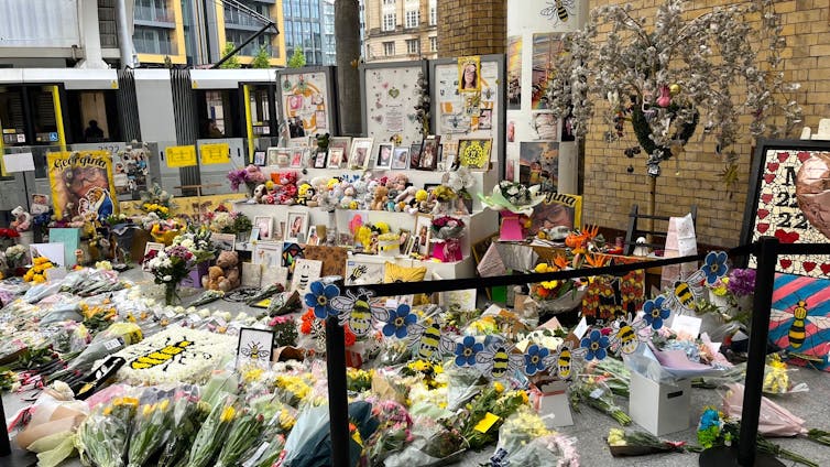 A large gathering of flowers and photos in a train station