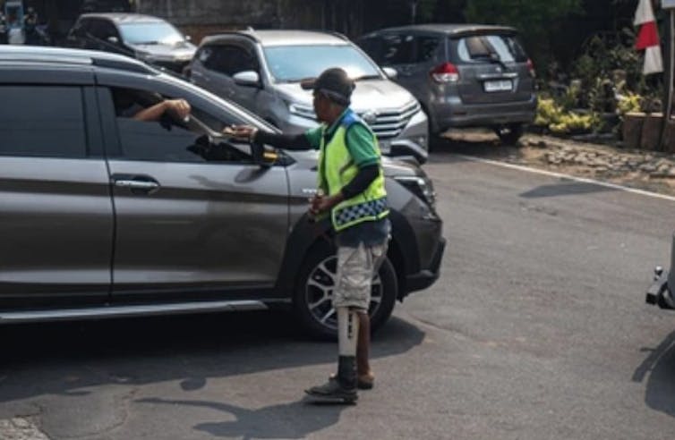 Pak Ogah yang sedang mengatur lalu lintas di suatu persimpangan jalan di Jakarta yang mengganggu