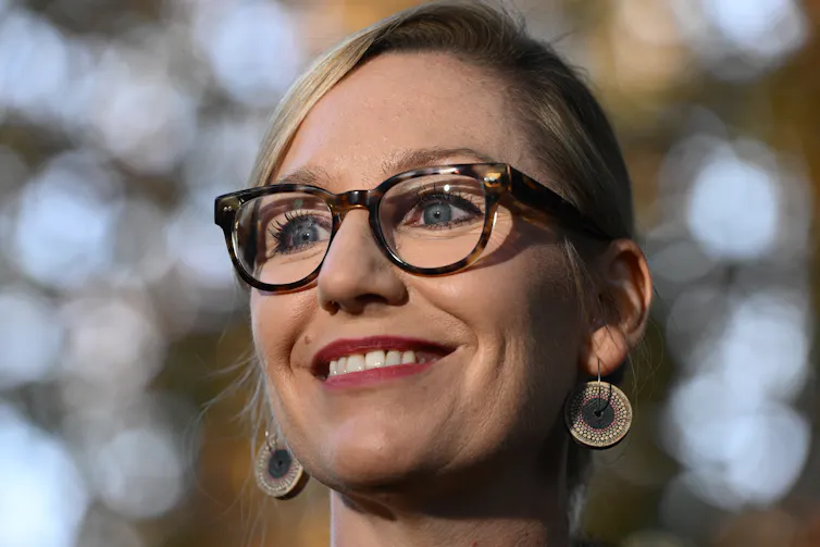 Head shot of a smiling Larissa Waters wearing glasses and large earrings