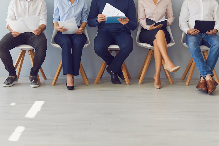 people waiting on chairs for a job interview