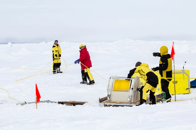 Scientists from a research icebreaker are establishing a remotely operated vehicle (ROV) camp over an ice floe to explore under ice algal growth.