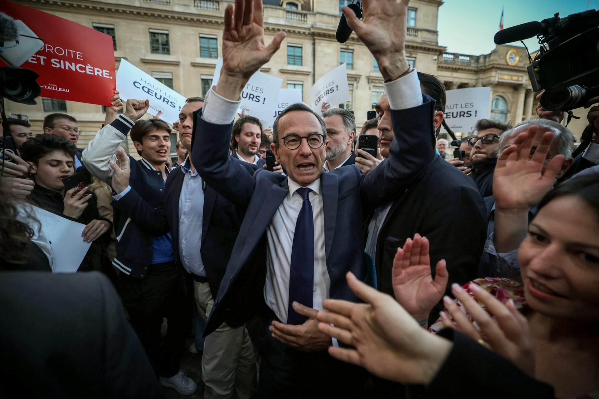 Le ministre français de l'Intérieur Bruno Retailleau lève les bras en l'air devant les militants, il a été désigné président de LR à Paris le 18 mai 2025. 
